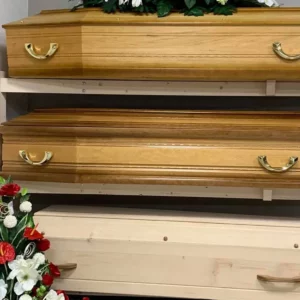Cercueils en bois présentés dans un magasin de pompes funèbres.