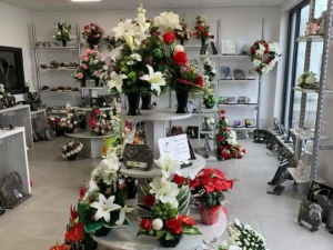 Boutique de pompes funèbres avec fleurs et plaques funéraires.