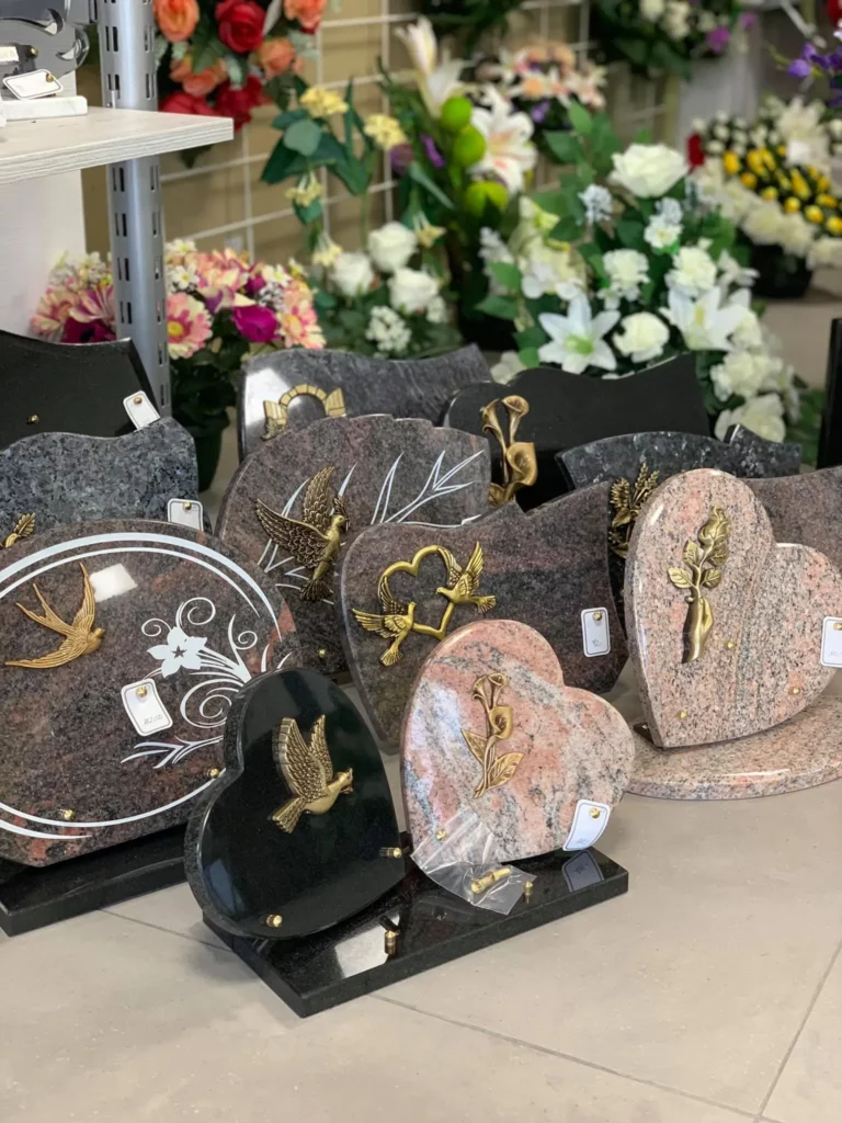 Exposition de plaques funéraires en granit de différentes formes.