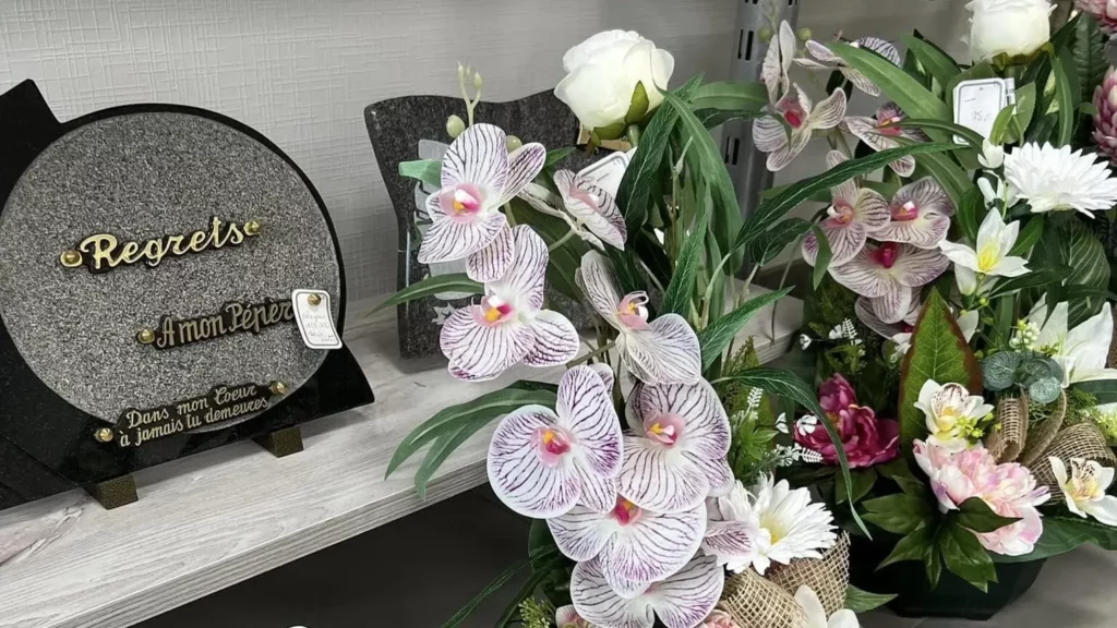 Plaque funéraire personnalisée et composition d'orchidées artificielles.