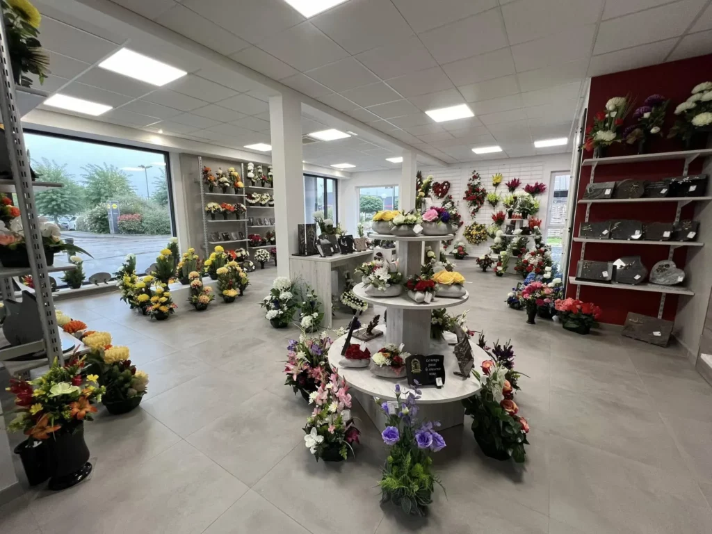 Vue d'ensemble de la boutique de pompes funèbres avec fleurs et ornements.