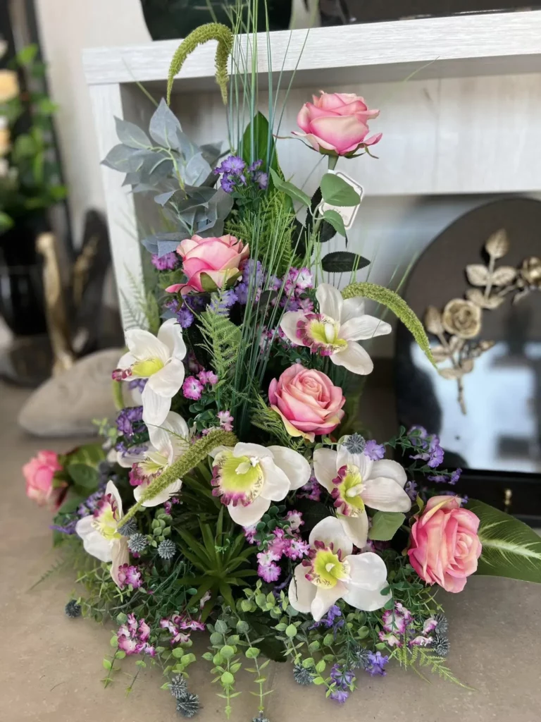 Bouquet de deuil composé de roses roses et d'orchidées blanches.