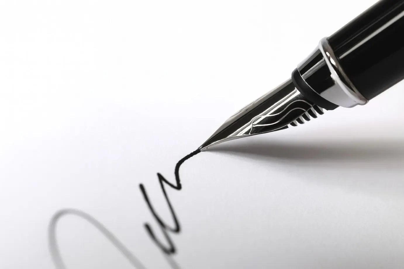 Gros plan sur un stylo-plume traçant une signature officielle sur du papier blanc.
